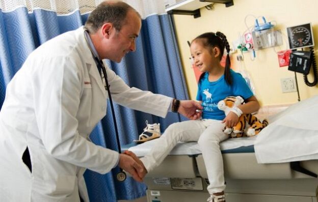 un médecin examine un enfant atteint d'arthrose de la hanche