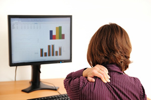Ostéochondrose cervicale chez une femme assise devant un ordinateur